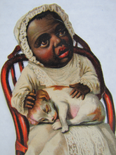 Load image into Gallery viewer, CREEPY LOOKING ANTIQUE BLACK AMERICANA CHILD IN DRESS WITH DOG IN CHAIR PAPER CUT-OUT
